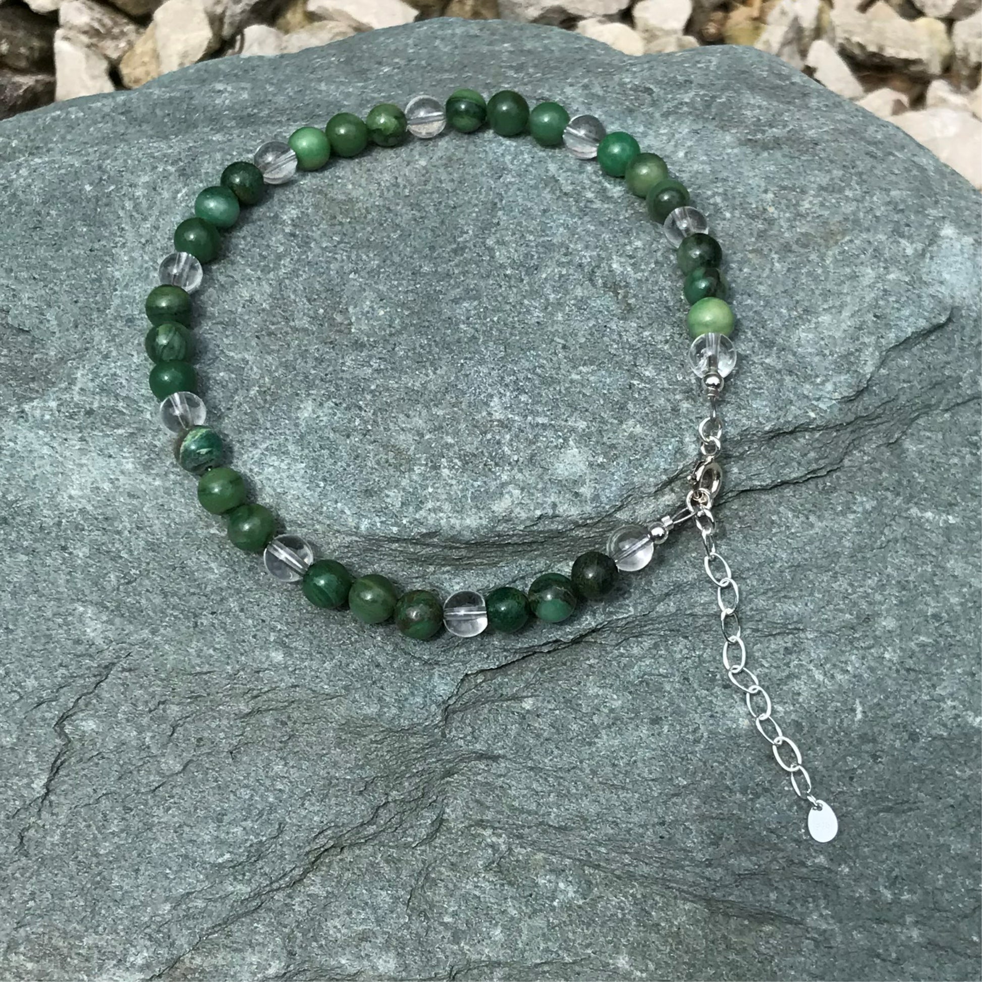 Dark green gemstone anklet on stone