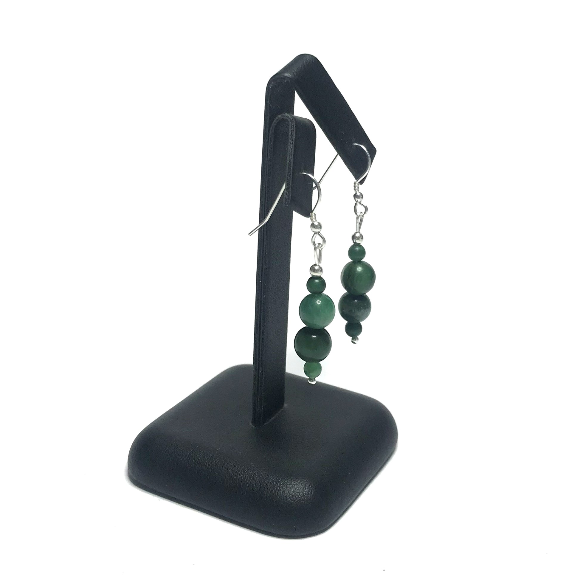 African jade dangle earrings on a black stand
