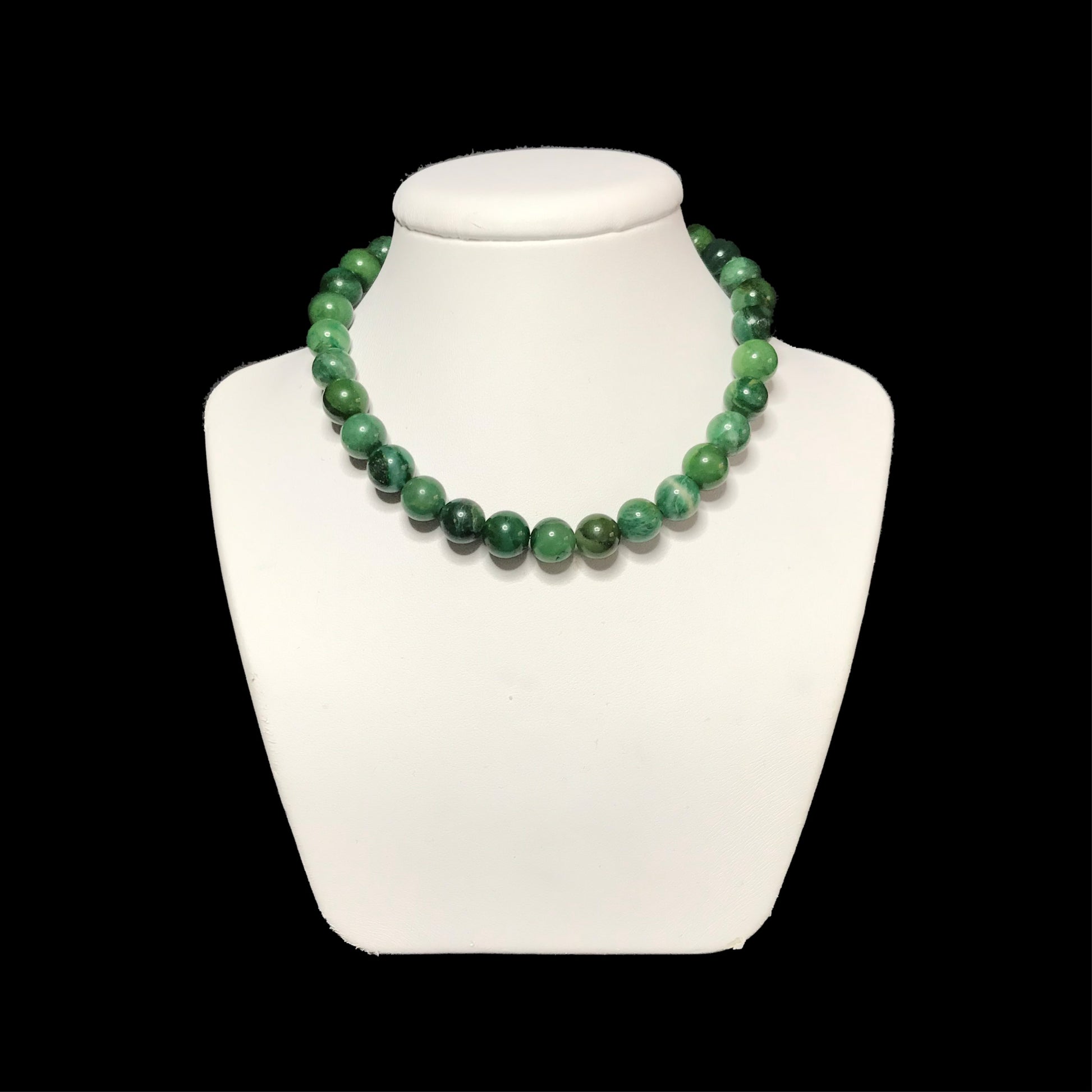 Green gemstone necklace on a white stand