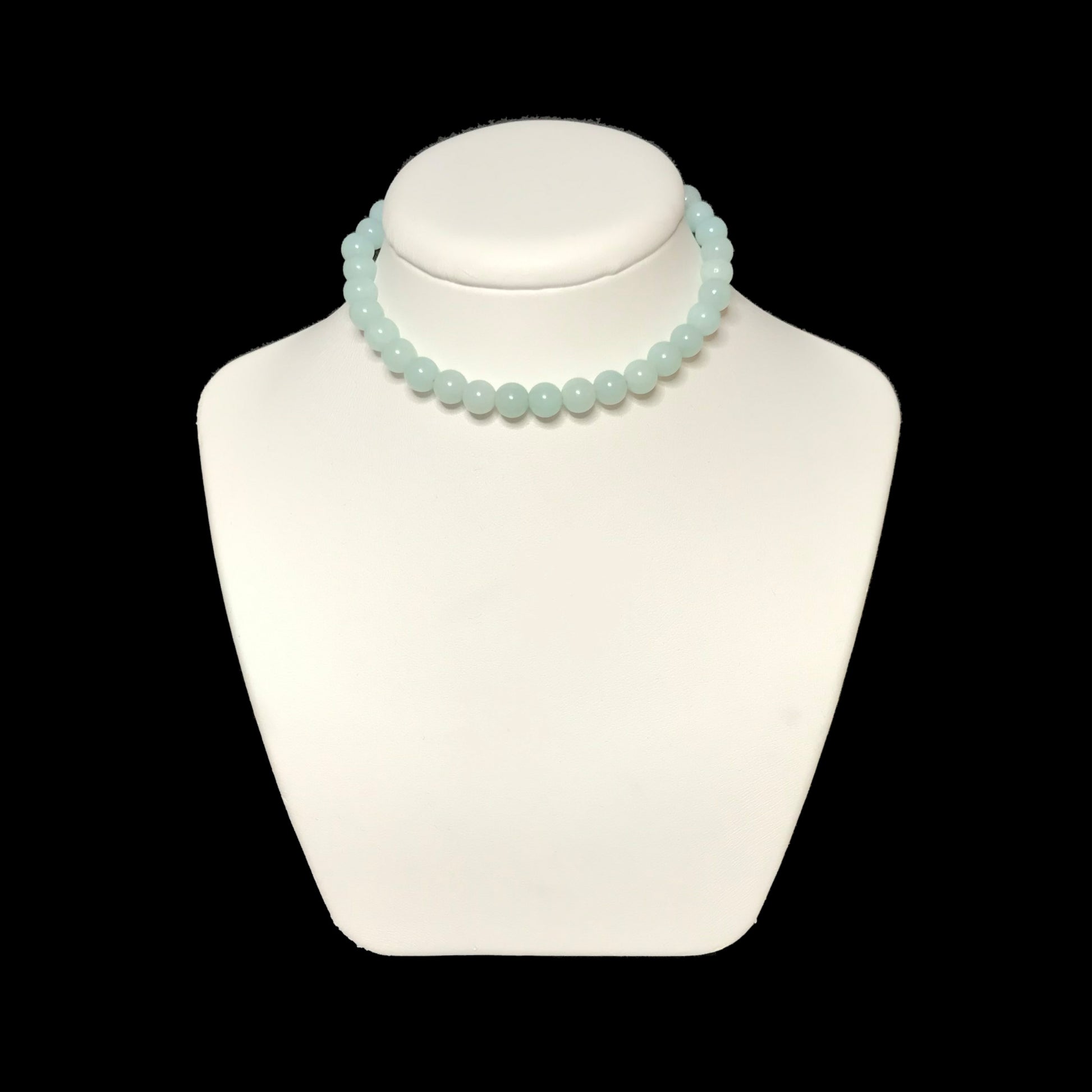 Gemstone necklace on a white stand