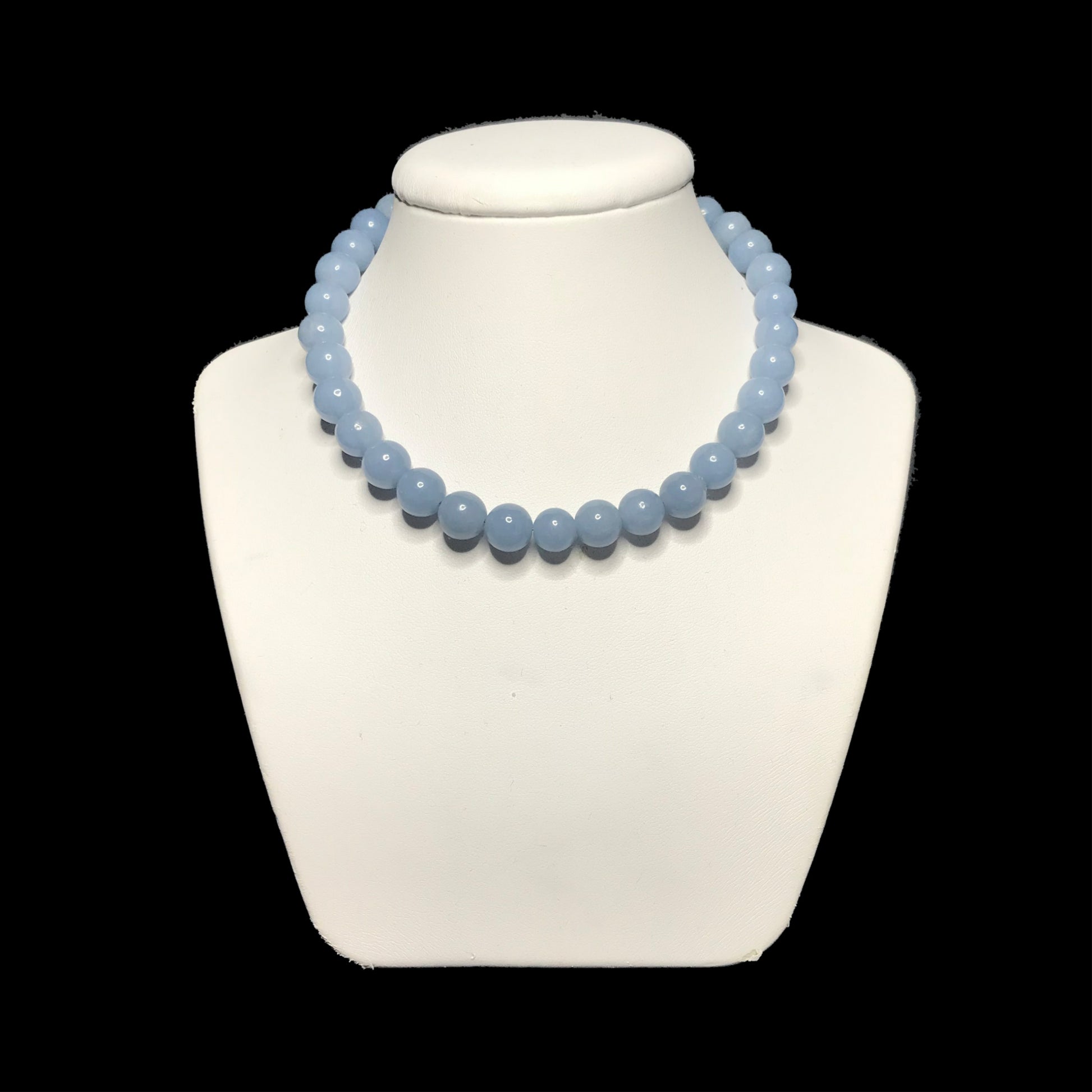 Pale blue necklace on a white stand