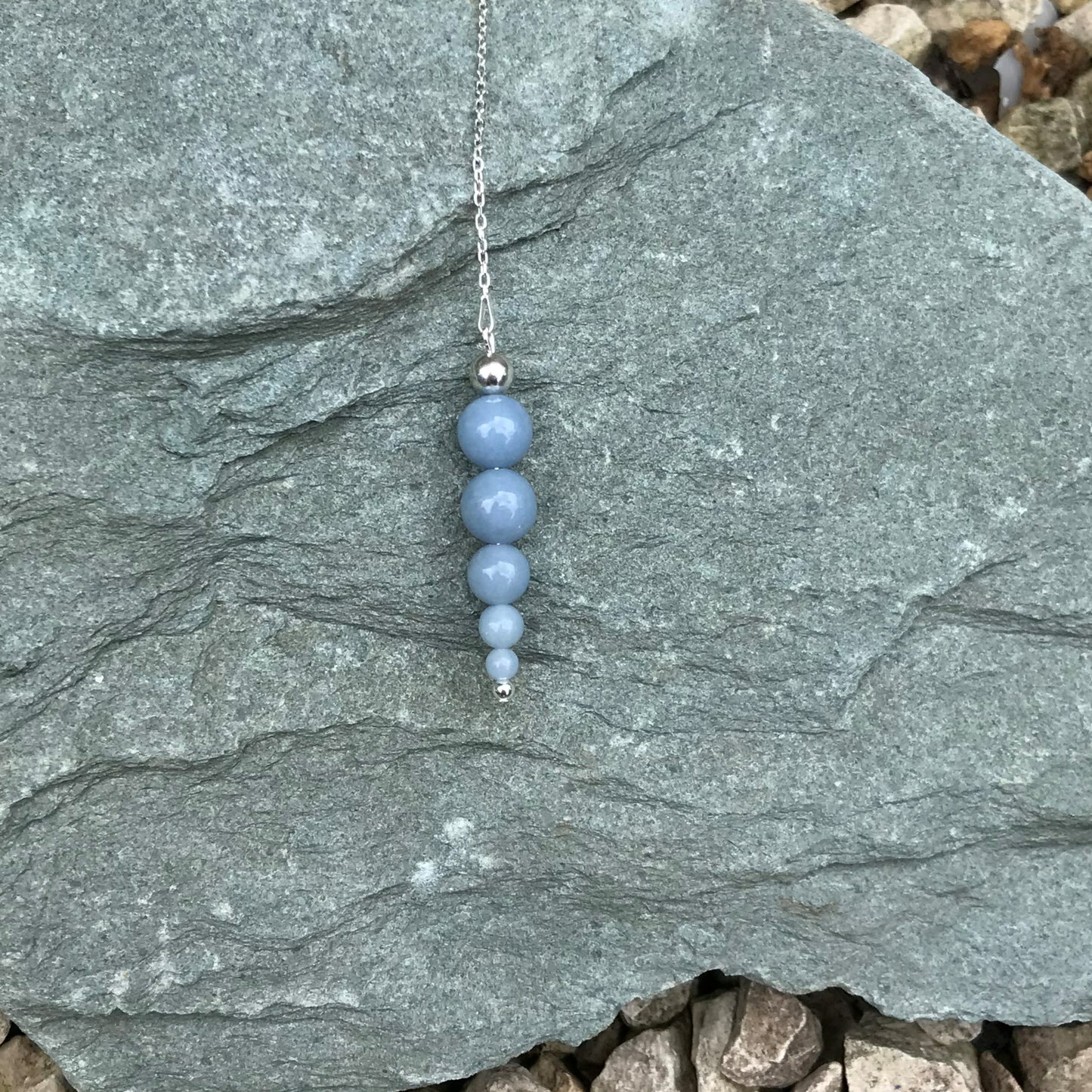 Crystal divination pendulum on stone