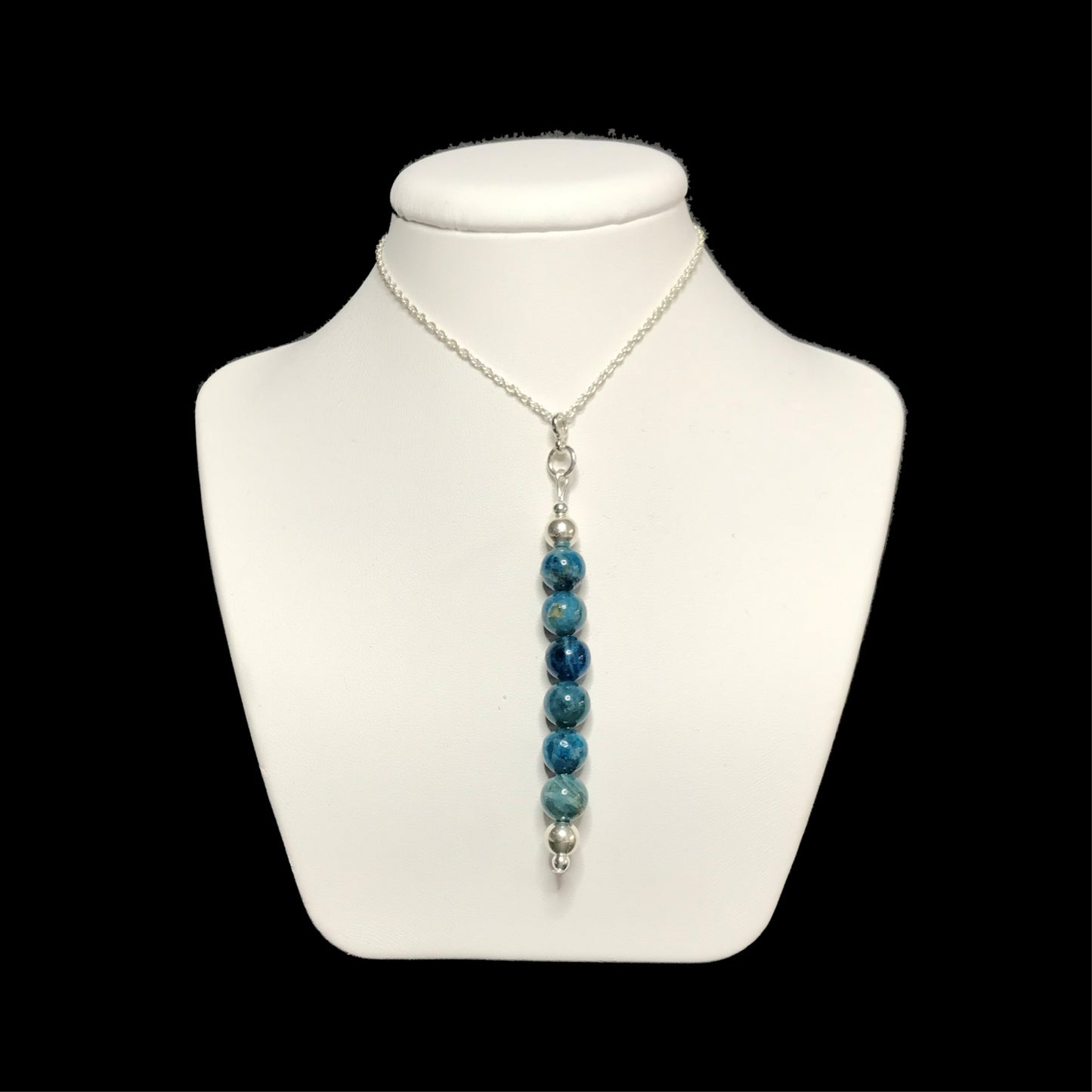 Blue gemstone pendant on a white stand