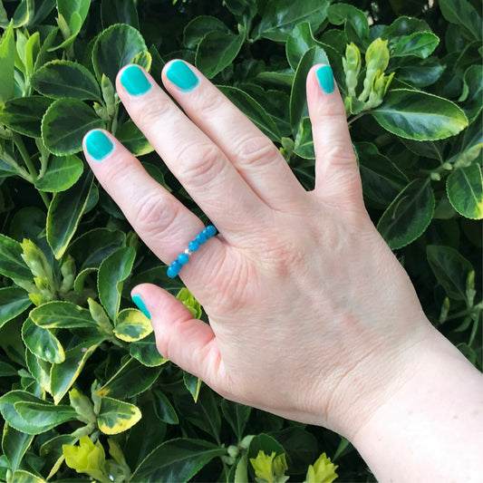 Hand wearing a blue crystal bead stetch ring