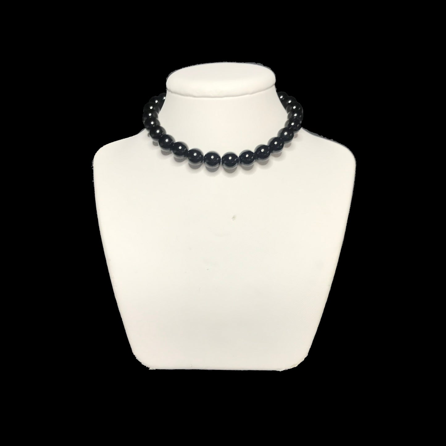 Black crystal necklace on a white stand