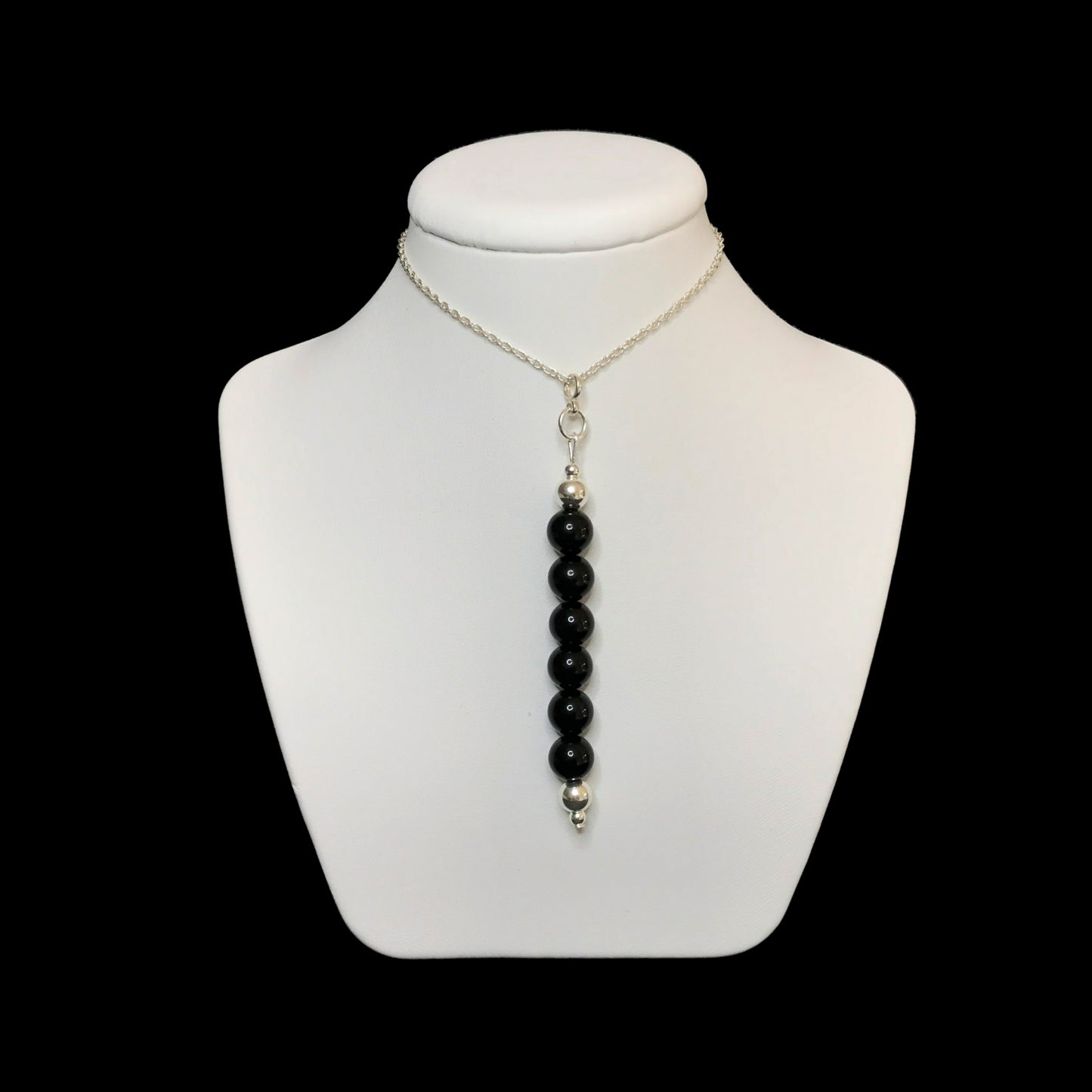 Black gemstone pendant on a white stand