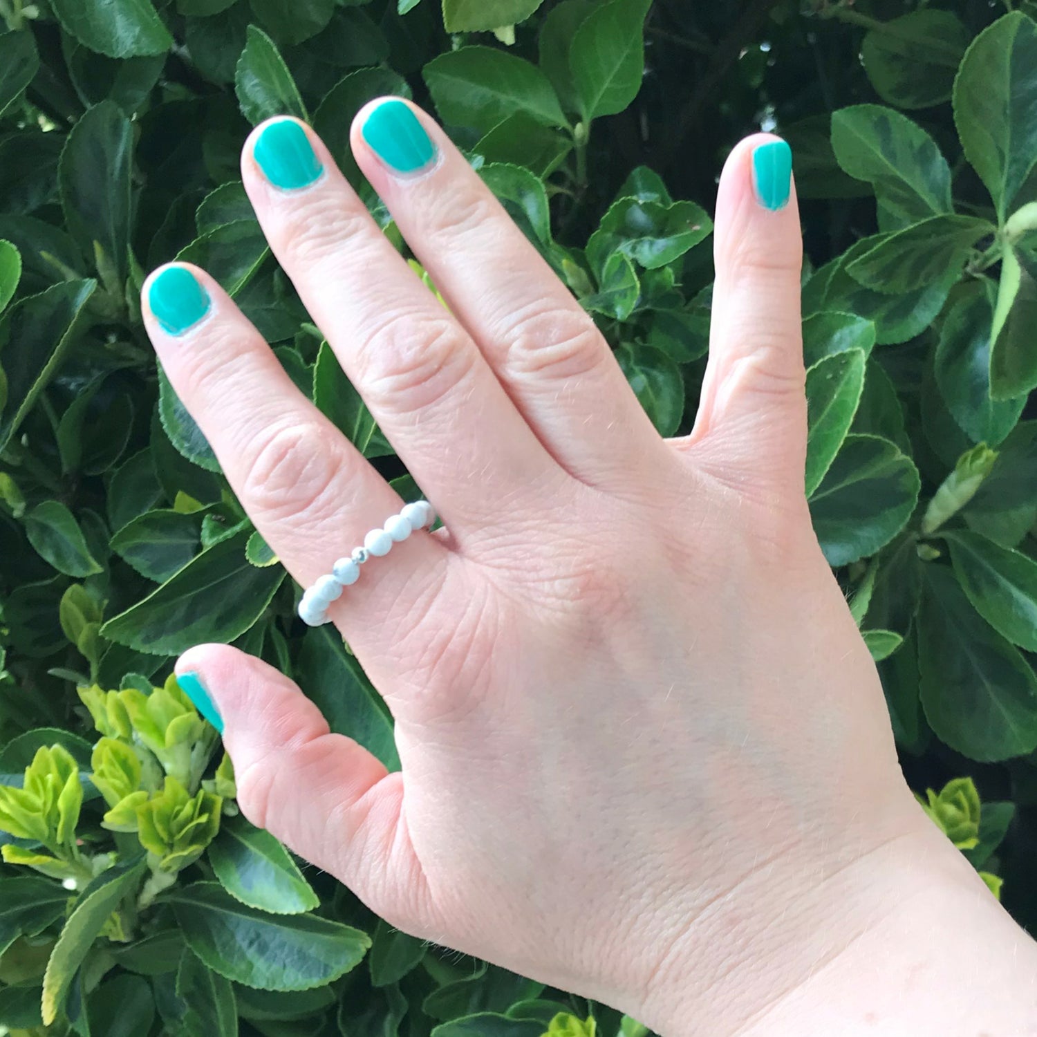 Hand wearing a blue lace agate beaded stretch ring