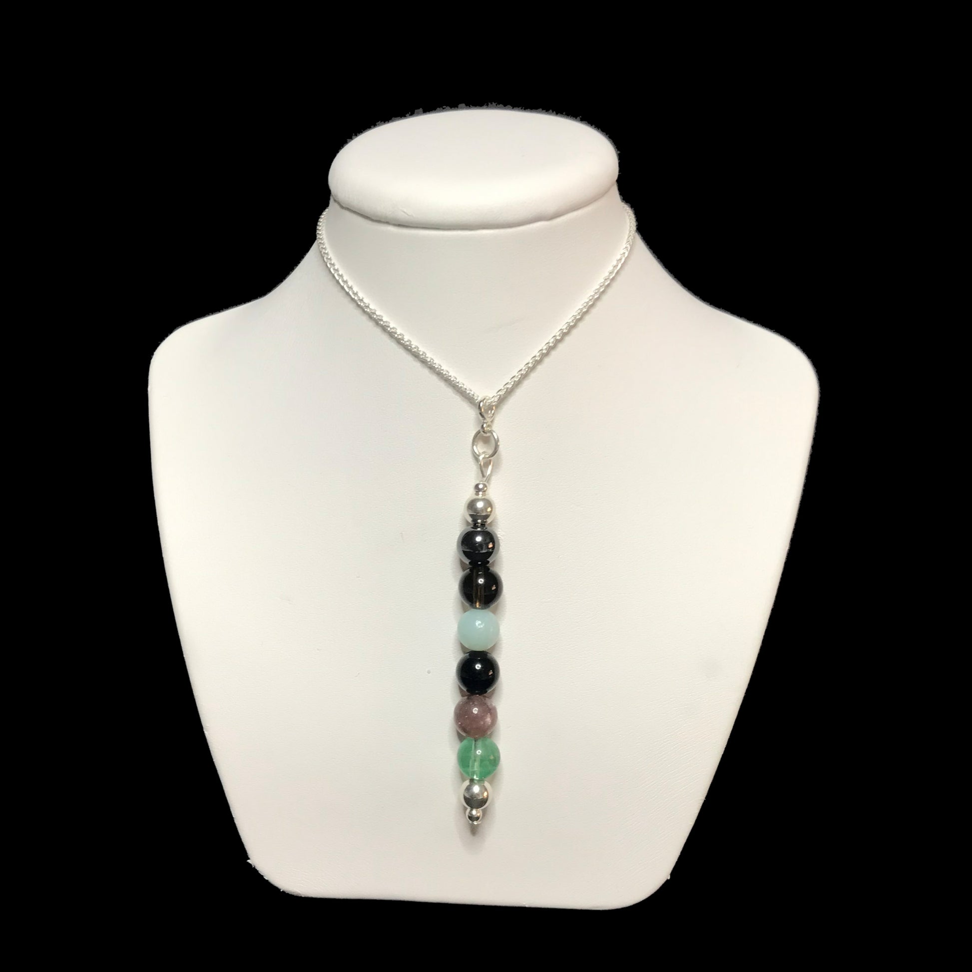 EMF protection crystal pendant necklace on a white stand