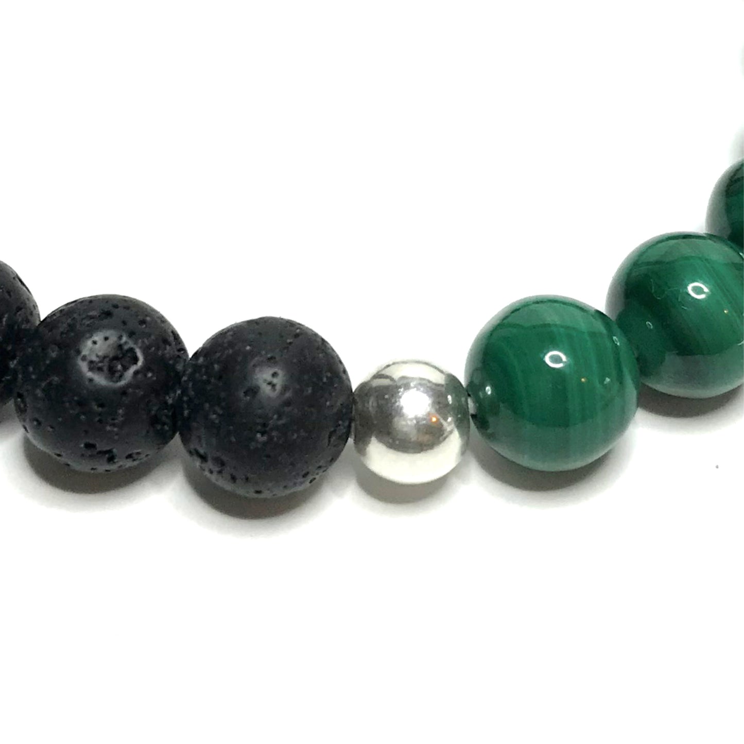 Close up of sterling silver bead between lava and malachite beads