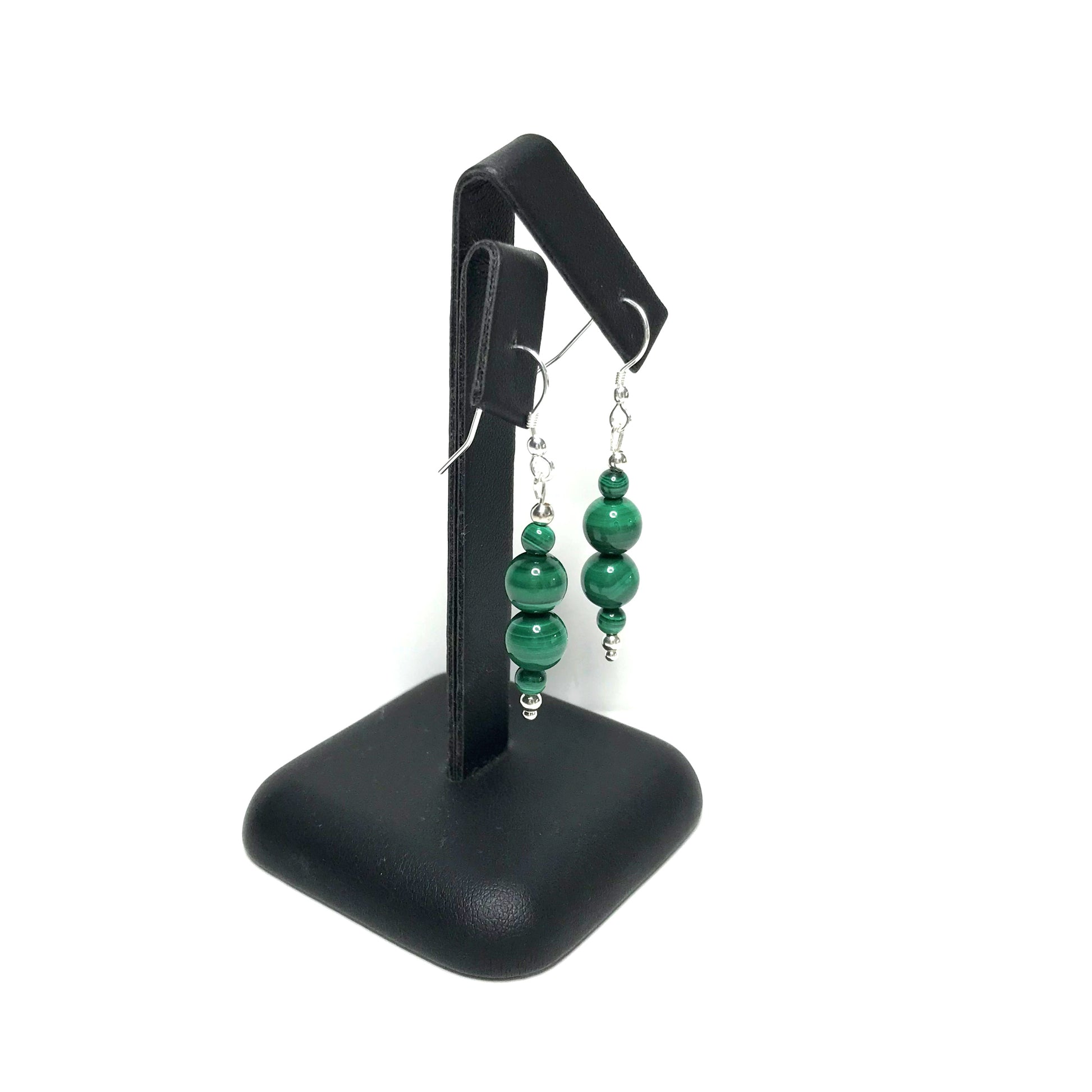 Green crystal dangle earrings on stand