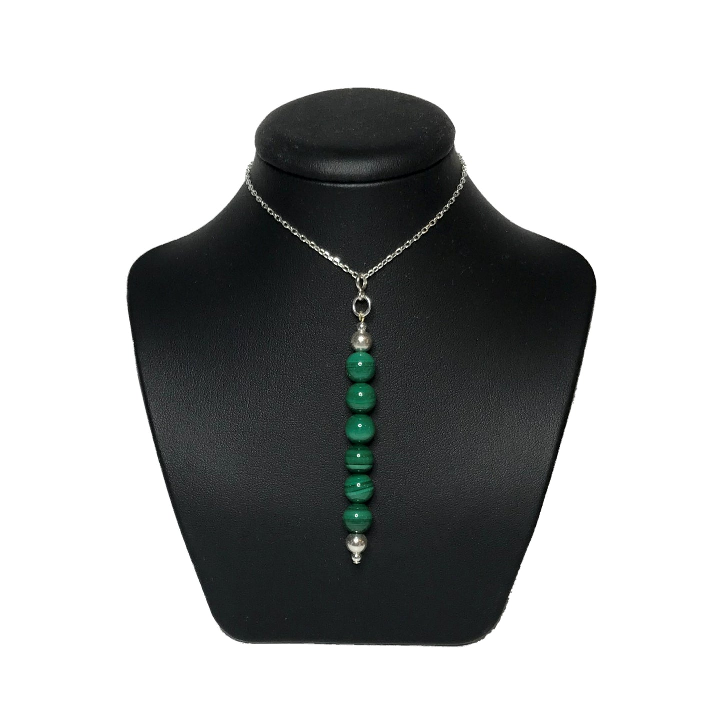 Green crystal bead pendant on a black stand