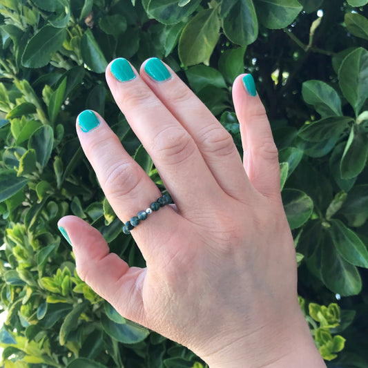 Hand wearing moss agate ring