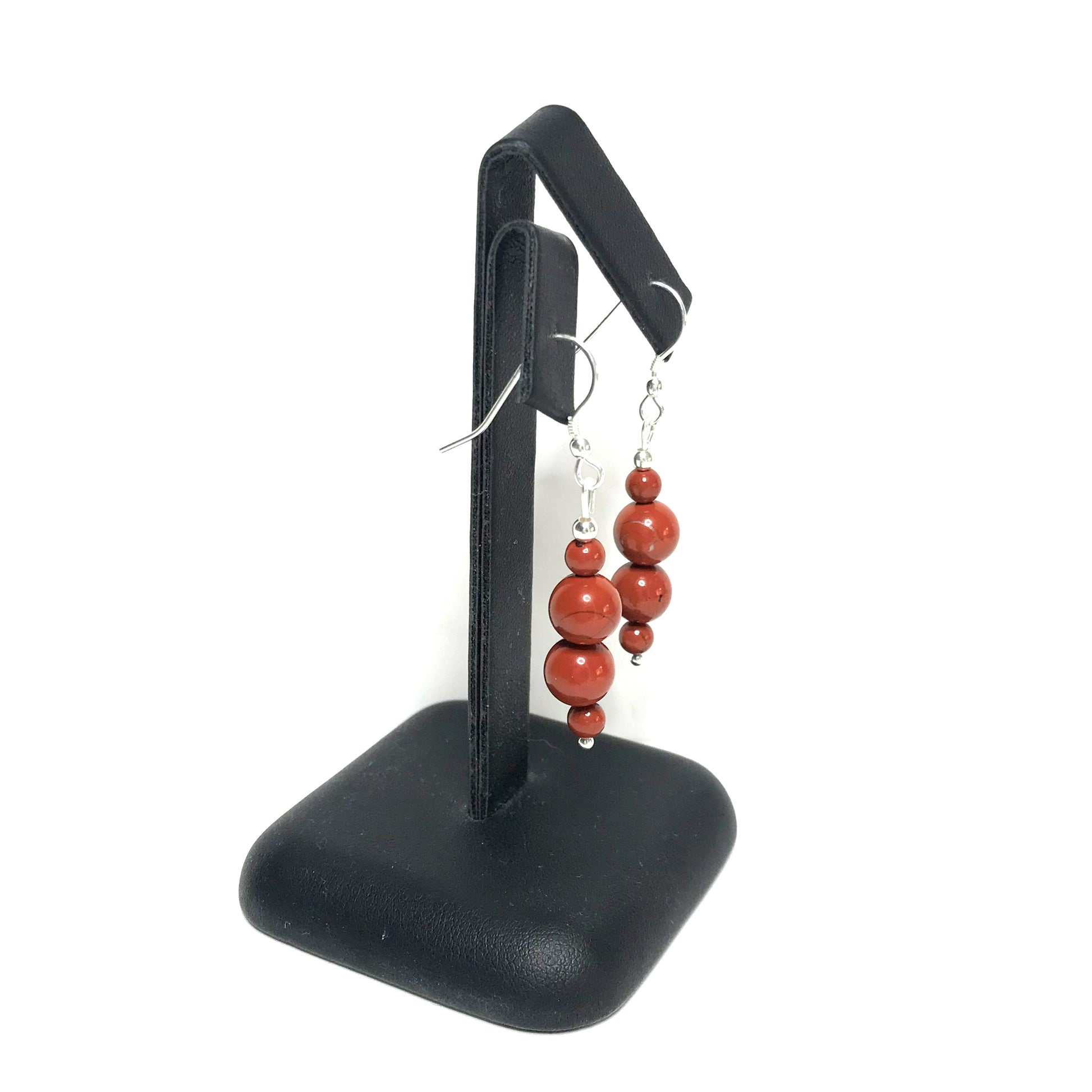 Red jasper crystal drop earrings on stand