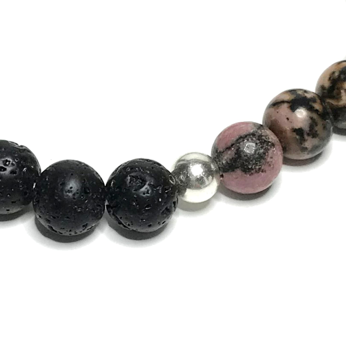 Close up of sterling silver bead between rhodonite and lava beads