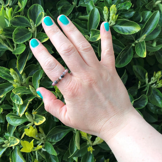 Hand wearing a rhodonite bead stretch ring