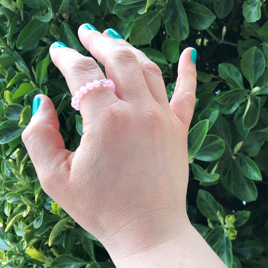 Hand weraring a rose quartz beaded stretch ring