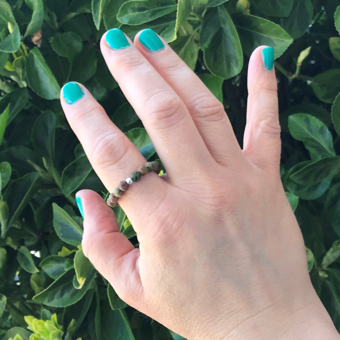 Hand wearing unakite stretch ring