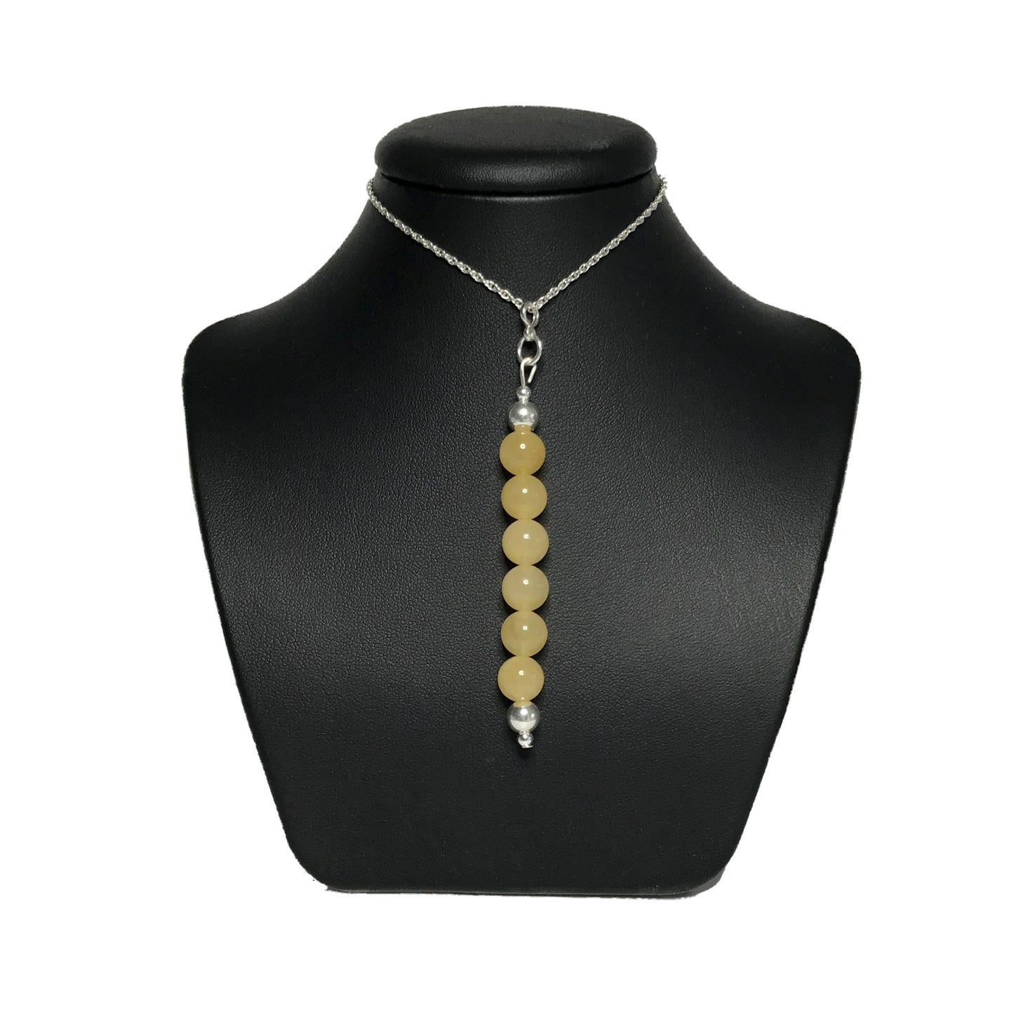 Yellow gemstone pendant necklace on a black stand