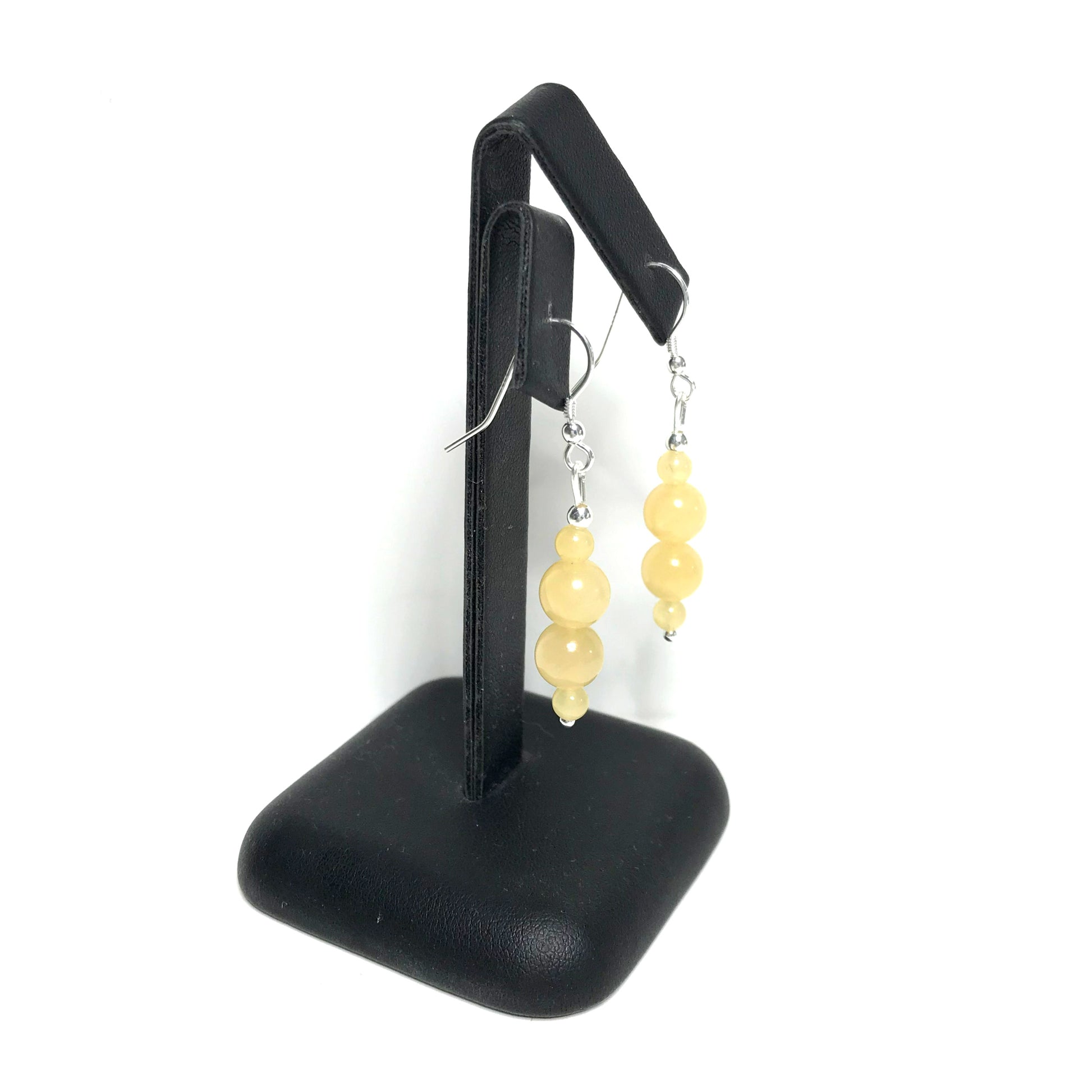 Yellow gemstone drop earrings on a stand