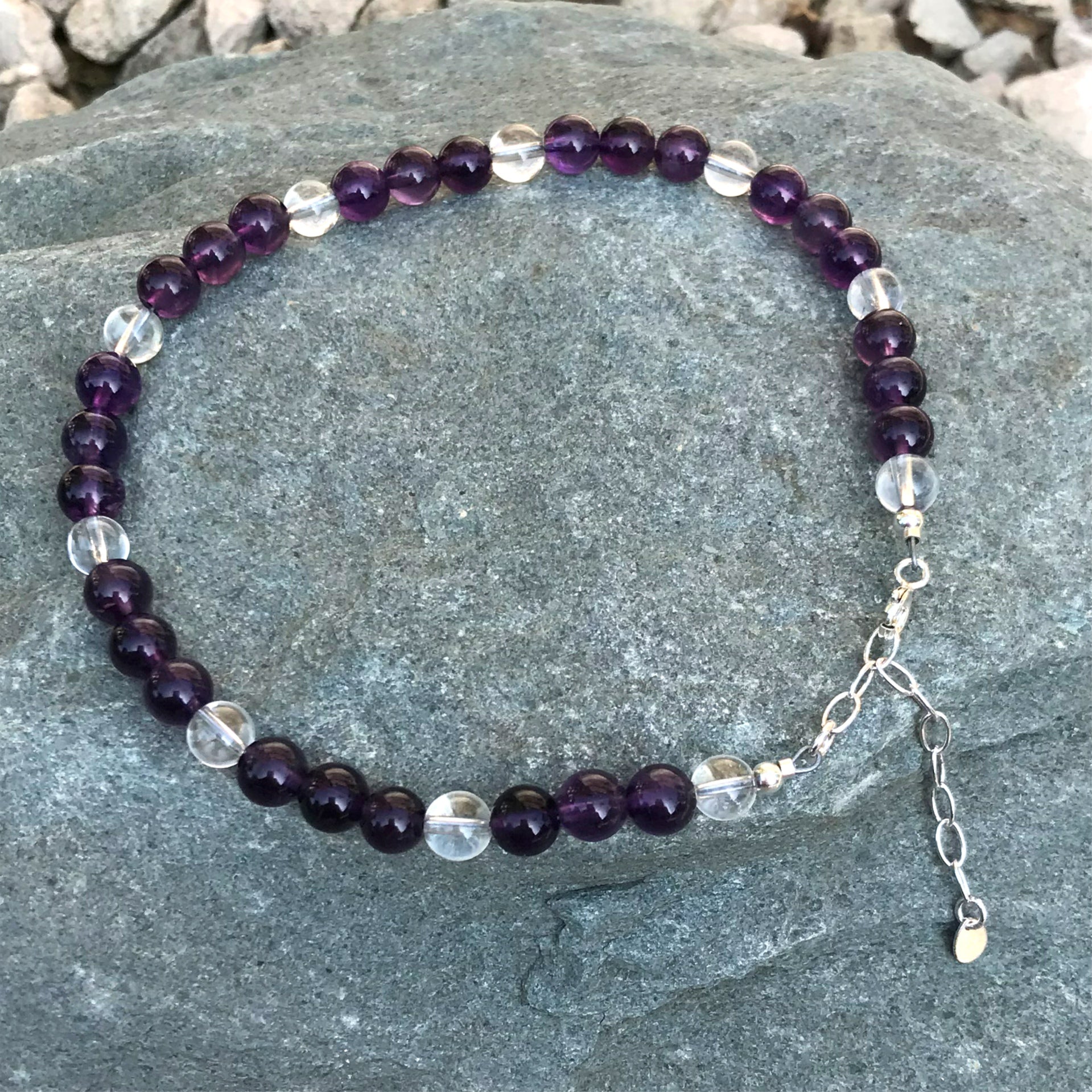 Purple gemstone anklet on stone