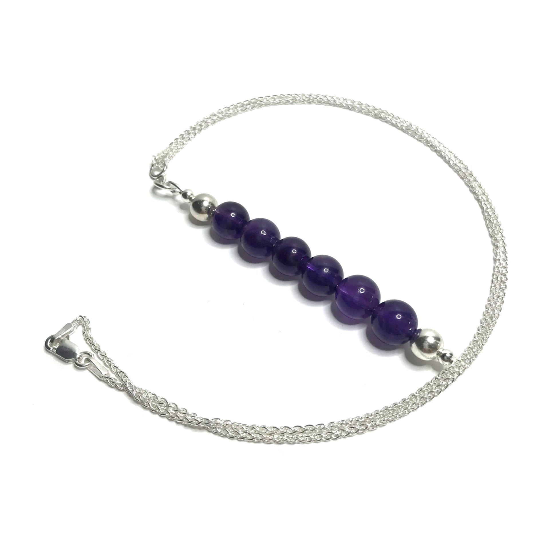 A handmade beaded amethyst pendant on a sterling silver chain.