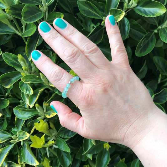 Hand wearing a green aventurine beaded stretch ring