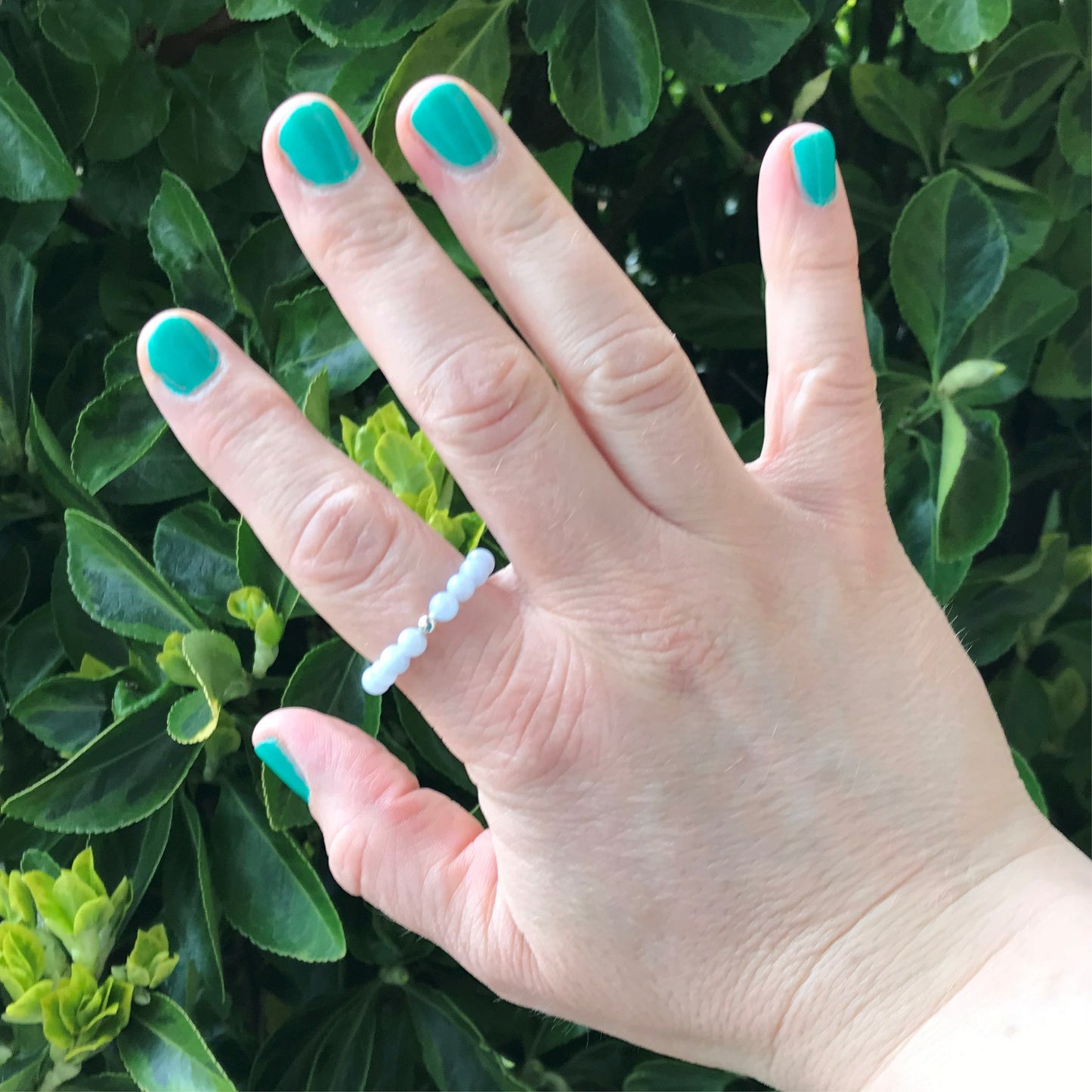 Hand wearing a howlite beaded stretch ring