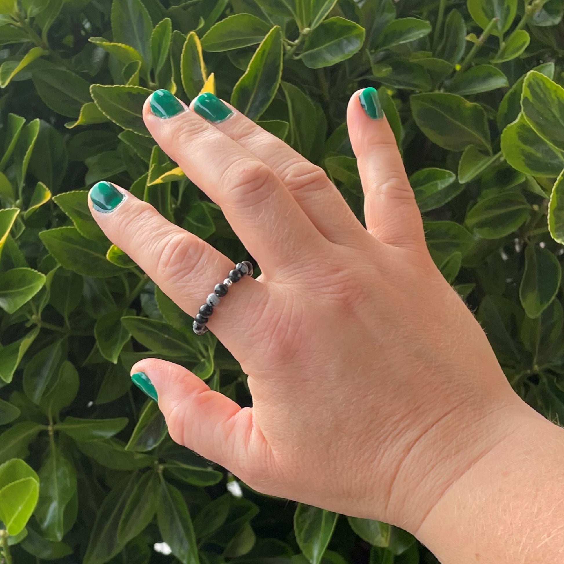 Hand wearing a snowflake obsidian ring