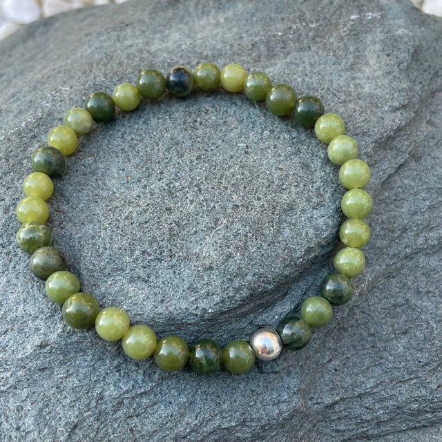 Handmade 6mm nephrite jade bracelet on a piece of slate outside