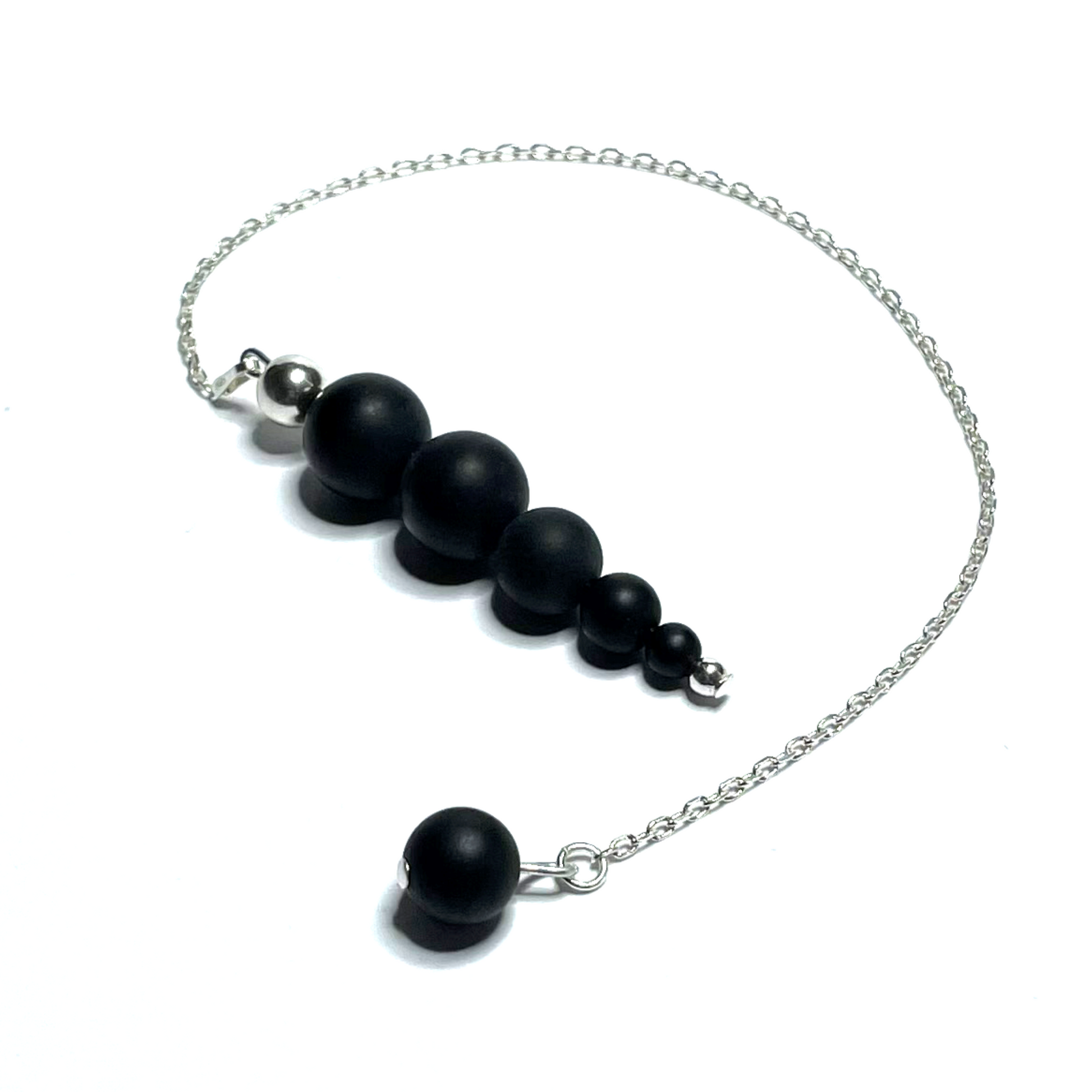 Handmade beaded matte onyx pendulum on a white background