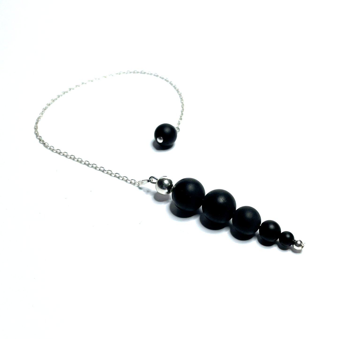 Handmade beaded matte onyx pendulum on a white background